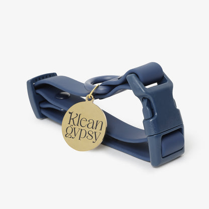 Navy blue dog collar with a gold tag on a white background
