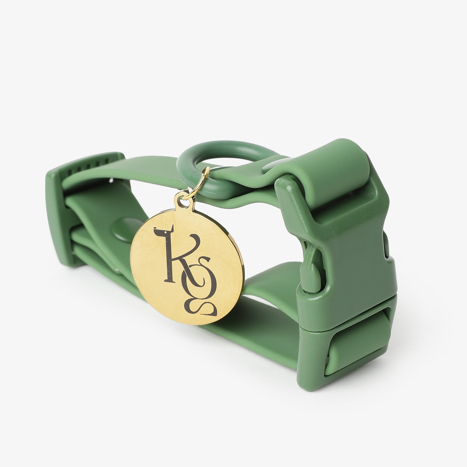 Green dog collar with a gold medallion on a white background